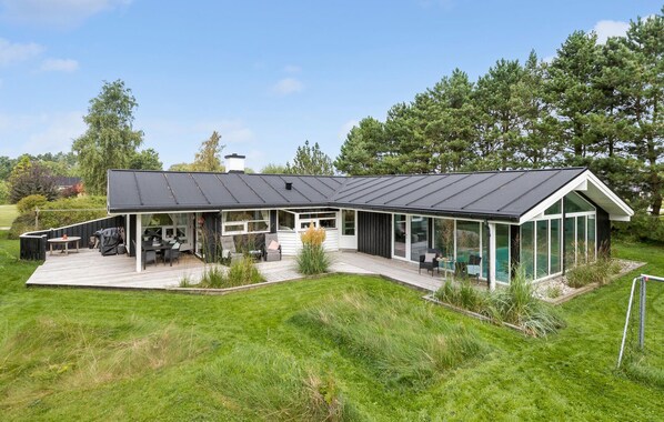 A modern house with a large deck, a covered patio, and a conservatory. - Stunning home in Knebel with sauna (Knebel)