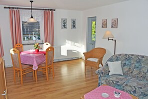 Un coin repas avec une table et des chaises, un canapé et une lampe.