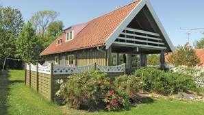 Een houten huis met schuin dak en een overdekte veranda.