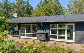 A building with large windows, a covered outdoor seating area, and a satellite dish. - Beautiful home in ålbæk with sauna (Ålbæk)