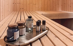 A wooden table with various scented oil bottles and a metal tray. - Beautiful home in ålbæk with sauna (Ålbæk)