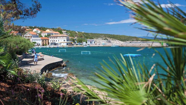 A coastal town with buildings, a pier, and clear blue water. - Holiday apartment with barbecue, internet and air conditioning (Šilo)