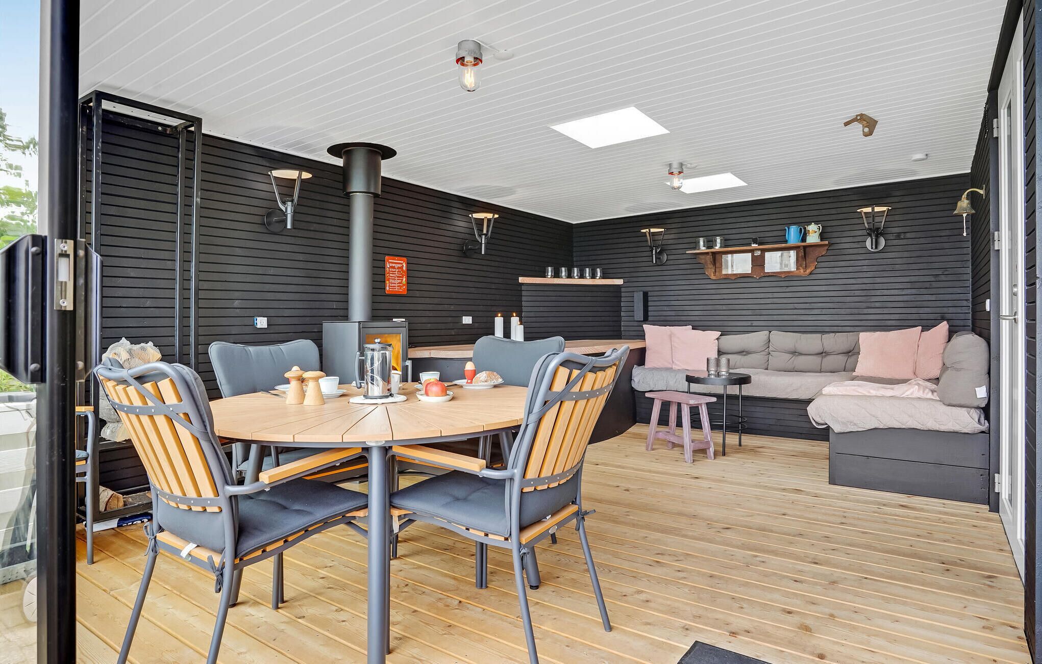 Un intérieur chaleureux avec une table ronde en bois, des chaises, un canapé et une cheminée.