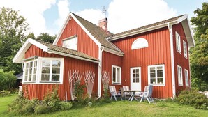 A red wooden house with a sloped roof, white trim, and multiple windows. - 4 bedroom stunning home in Färgelanda (Färgelanda)