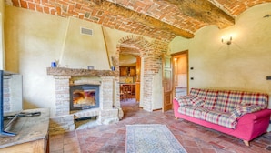 A cozy living room with a fireplace, a pink sofa, and a rustic brick ceiling. - Lovely home in Aramengo AT (Aramengo AT)