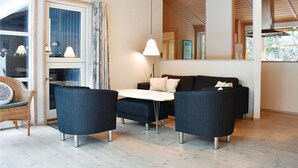 A modern living room with a sofa set, a dining table, and a wicker chair. - Gorgeous home in Væggerløse with WiFi (Væggerløse)