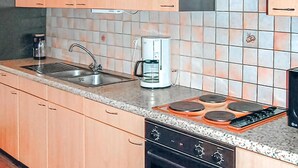 Et køkken med vask, kaffemaskine, komfur og ovn.
