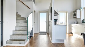 Eine moderne Küche mit Einbauherd, Kaffeemaschine und Blick ins Freie.