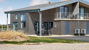 Ein modernes, zweistöckiges Gebäude mit Backsteinfassade, großen Fenstern und einem Balkon.