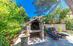 Outdoor cooking area surrounded by lush greenery and a serene garden setting.