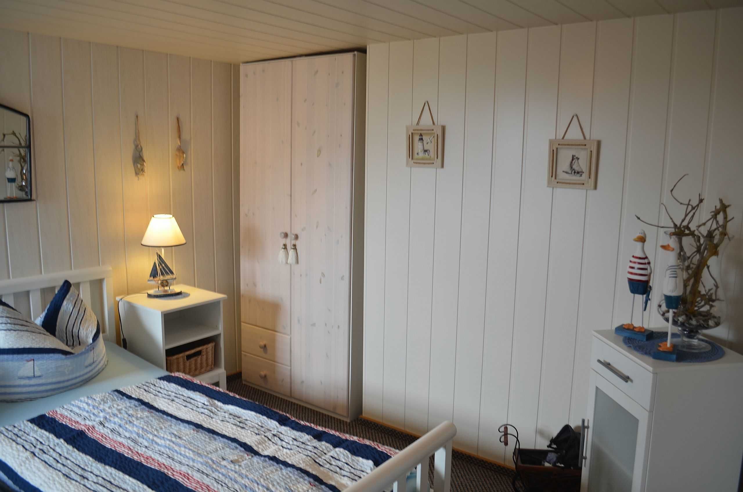 Un dormitorio con cama, mesita de noche, cómoda y armario.