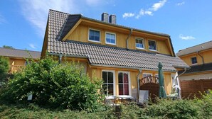 A two-story house with a sloped roof, a wooden exterior, and a visible chimney. - Usedom tourist Koserow Hauptstr. DHH 14 - DHH 14 (Koserow)