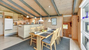 Un'ampia cucina con mobili in legno, un'isola centrale e luci a sospensione.