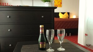 Een kamer met een bed, een kaptafel, een fles champagne en twee glazen op een tafel.