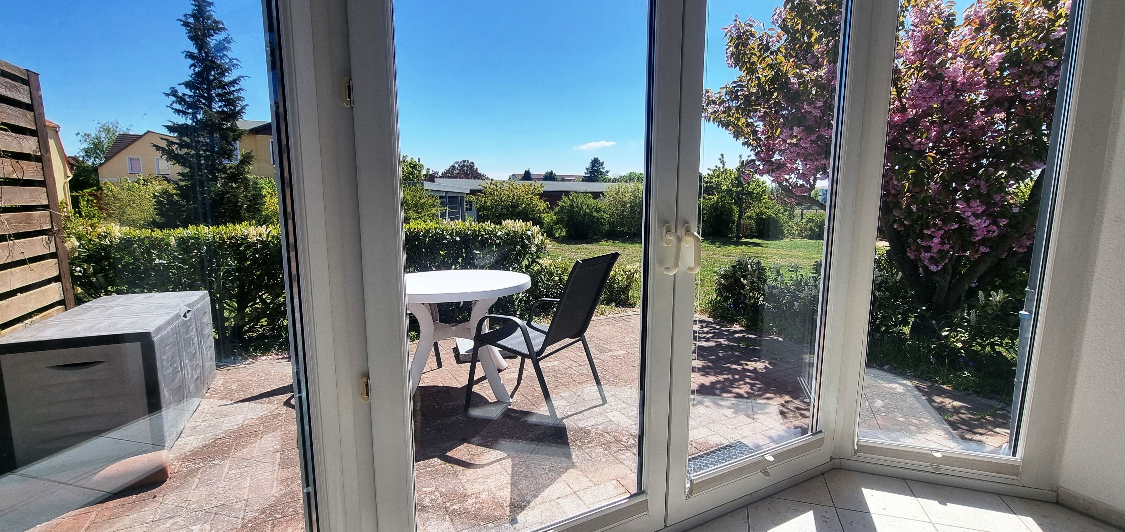 A room with a sliding glass door leading to a patio with a table and chairs.