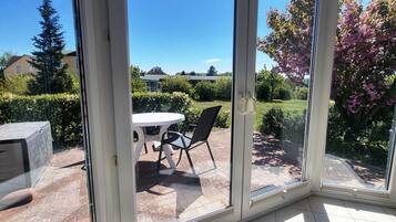 A room with a sliding glass door leading to a patio with a table and chairs.