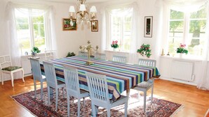 A dining room with a long table, six chairs, and a chandelier. - Beautiful home in Dalum with kitchen (Dalum)