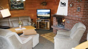 A cozy living room with a fireplace, a television, and comfortable seating.