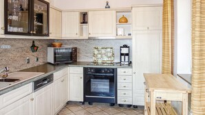 A compact kitchen with white cabinets, a microwave, a toaster, and a coffee maker.