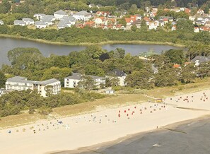 Een kustplaatsje met een strand, huizen en een meer.