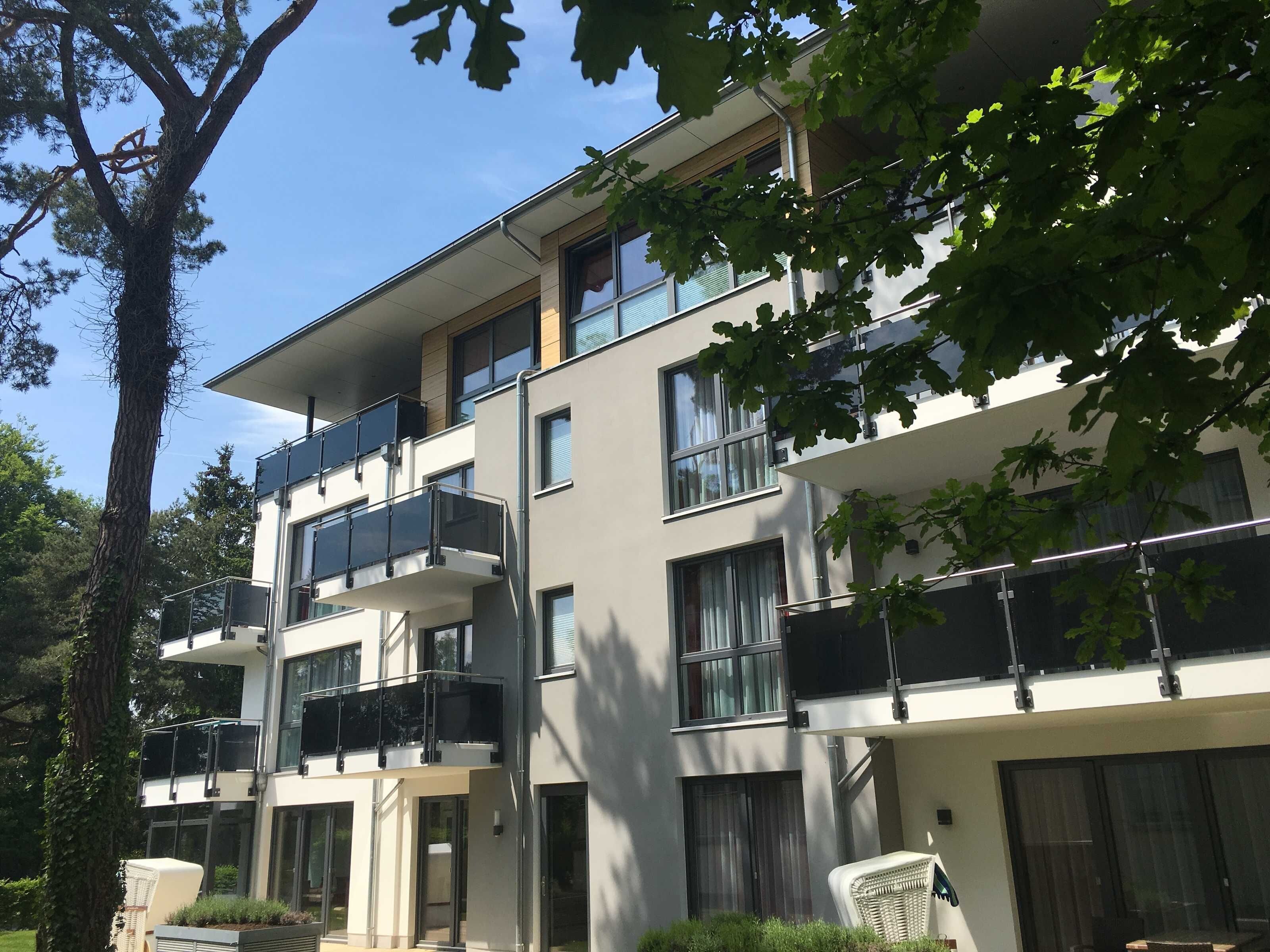A multi-story residential building with balconies, large windows, and a modern architectural style.