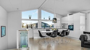 Eine moderne Küche mit Essbereich, großen Fenstern und Blick auf die Nachbarschaft.