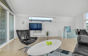 Relax in this stylish living space with a flat-screen TV, comfortable sofa, and a coffee table for socializing.