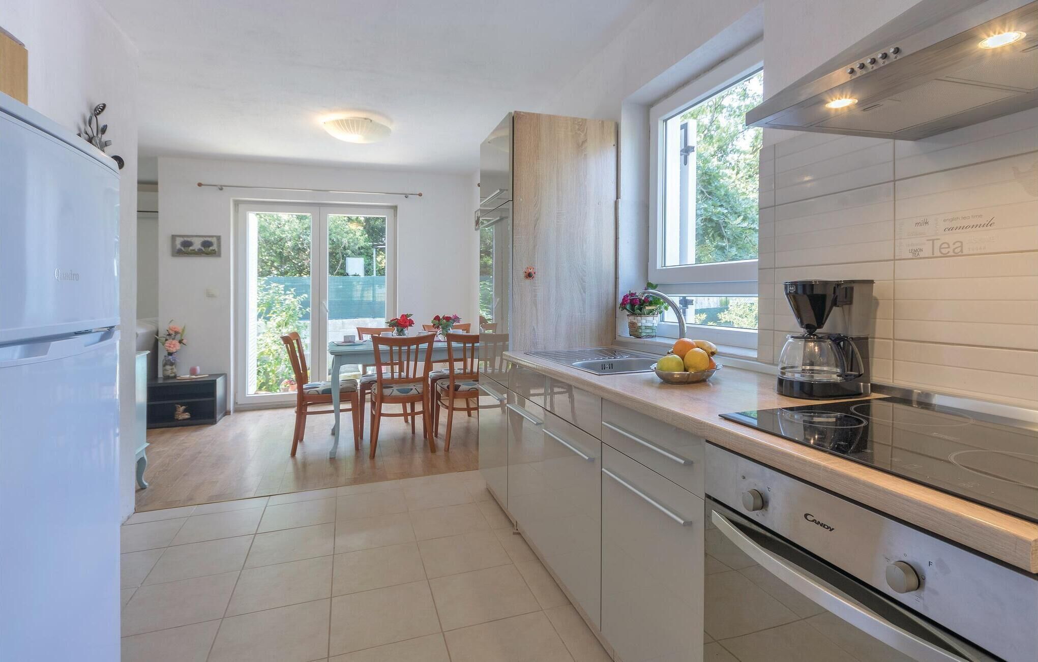 Una cocina moderna con zona de comedor, ventanas amplias y cafetera.