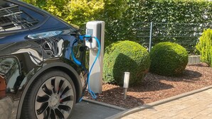 Un vehículo eléctrico negro cargando en una estación.