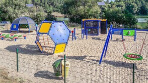 Ein Spielplatz mit Klettergerüsten, Schaukeln und einem umzäunten Bereich.