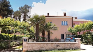 A two-story building with a stone facade, a balcony, and a car parked in front. - 2 bedroom awesome apartment in Fazana (Fazana)