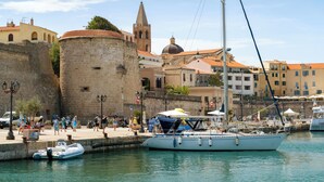 A coastal town with a historic fort, a church with a bell tower, and a marina with boats. - Holiday home with air conditioning (Alghero)