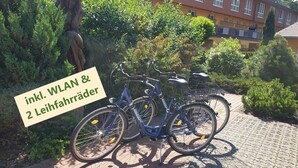 En cykel parkeret på en belagt plads med en bygning i baggrunden.