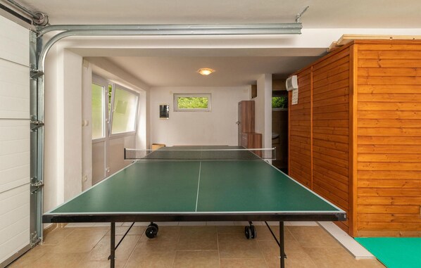 A ping pong table in a room with a wooden cabinet and a window. - Pet friendly home in Dolinci with sauna (Dolinci)