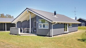 Une maison de plain-pied dotée d’un patio couvert, d’une cheminée et d’une antenne parabolique.
