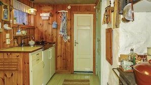 Un intérieur en bois comprenant un espace cuisine, avec un évier, une cuisinière et des placards.
