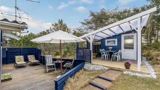 Una terraza con mobiliario exterior, un porche cubierto y vistas del paisaje circundante.