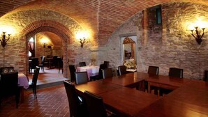 A dining area with a brick ceiling and stone walls, featuring tables and chairs arranged for dining. - Holiday apartment with pool (Castelluccio Capolona)