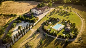 An aerial view of a large estate with a swimming pool, tennis courts, and a well-maintained lawn. - Holiday apartment with pool (Castelluccio Capolona)