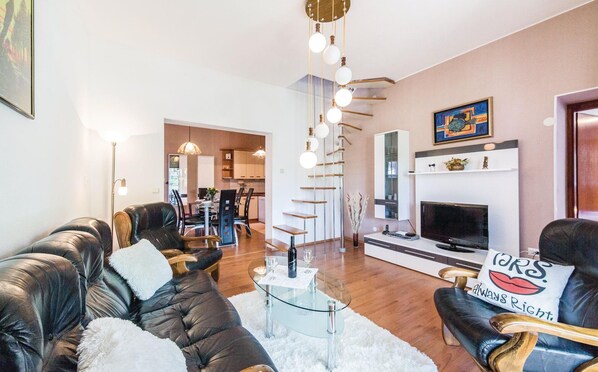 A modern living room with leather sofas, a glass coffee table, a fireplace, and a dining area in the background. - Beautiful home in Kastel Gomilica with WiFi (Kastel Gomilica)