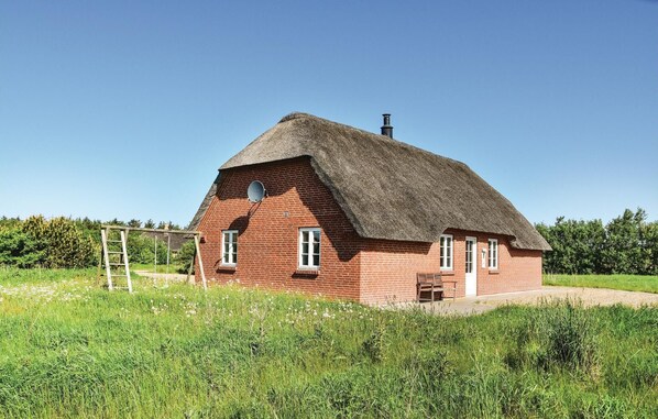 A red brick house with a thatched roof, a satellite dish, and a chimney. - Amazing home in Ulfborg with sauna (Ulfborg)