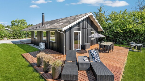 A modern cabin with a deck, outdoor seating, and a covered patio area. - Cozy home in Sydals with sauna (Sydals)