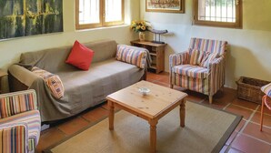A cozy living room with a sofa, striped armchairs, a small wooden coffee table, and a rug. - Awesome home in Gonfaron (Gonfaron)