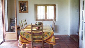A dining area with a table set for six, surrounded by wooden chairs. A fruit bowl is on the table, and there is a framed picture on the wall. - Awesome home in Gonfaron (Gonfaron)