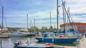 Uma marina com vários barcos atracados, incluindo um barco branco com a inscrição "METKA".