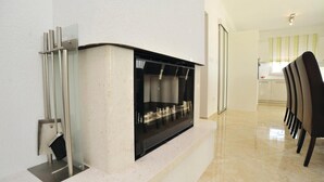 A modern kitchen with a built-in microwave, a stainless steel range hood, and a dining area with a chair. - Amazing home in Pakostane (Pakostane)