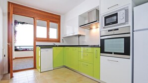 A kitchen with white and green cabinets, a dishwasher, a microwave, and an oven. - Nice home in Tossa de Mar with WiFi (Tossa de Mar)