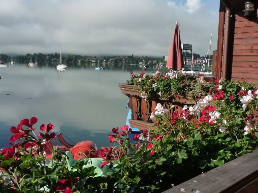 En utsikt över vattnet med båtar, en träbyggnad och en blomsteruppsättning.