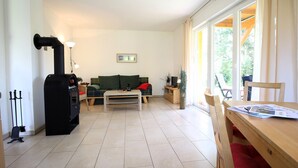 Una sala de estar acogedora con chimenea, un sofá, una mesa de centro y un comedor con mesa y sillas.