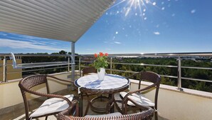 A balcony with wicker furniture, a table with a lace tablecloth, and a vase with flowers. - Cozy apartment in Vodice with house sea view (Vodice)